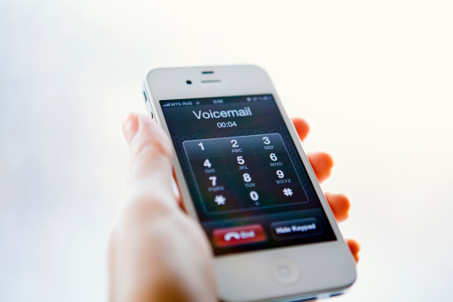 Nizhnevartovsk, Russia - March 2, 2013: Woman hand holding iPhone with Voicemail. iPhone is product Apple Inc.