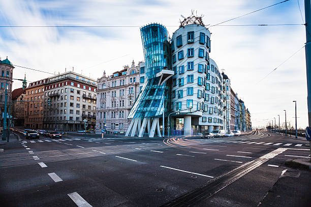 The Dancing House in Prague, Czech Republich "Prague, Czech Republich - January 2, 2013: The Dancing House one of the city's landmark standing in front of a congested crossroad. The building was designed by Vlado Milunia! in co-operation with Frank GCroatianehry." dancing house prague stock pictures, royalty-free photos & images