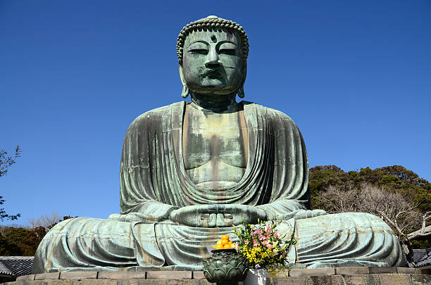 Great Buddha of Kamakira "Kamakura, Japan - February 20, 2013: The Great Buddha or Daibutsu of Kamakura, an 11.4 meter tall bronze statue of the Amida Buddha completed in the 13th century, is one of Kamakura's most famous religious sites." bronze statue stock pictures, royalty-free photos & images