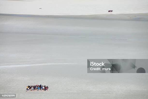 Foto de Os Turistas Trekking Na Lama Praia Na Maré Baixa e mais fotos de stock de Areia - Areia, Atividade, Cruzar