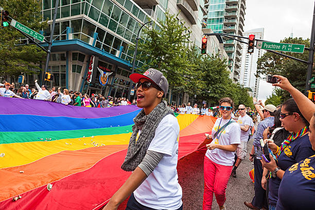 portare il gigante della bandiera arcobaleno - atlanta pride foto e immagini stock