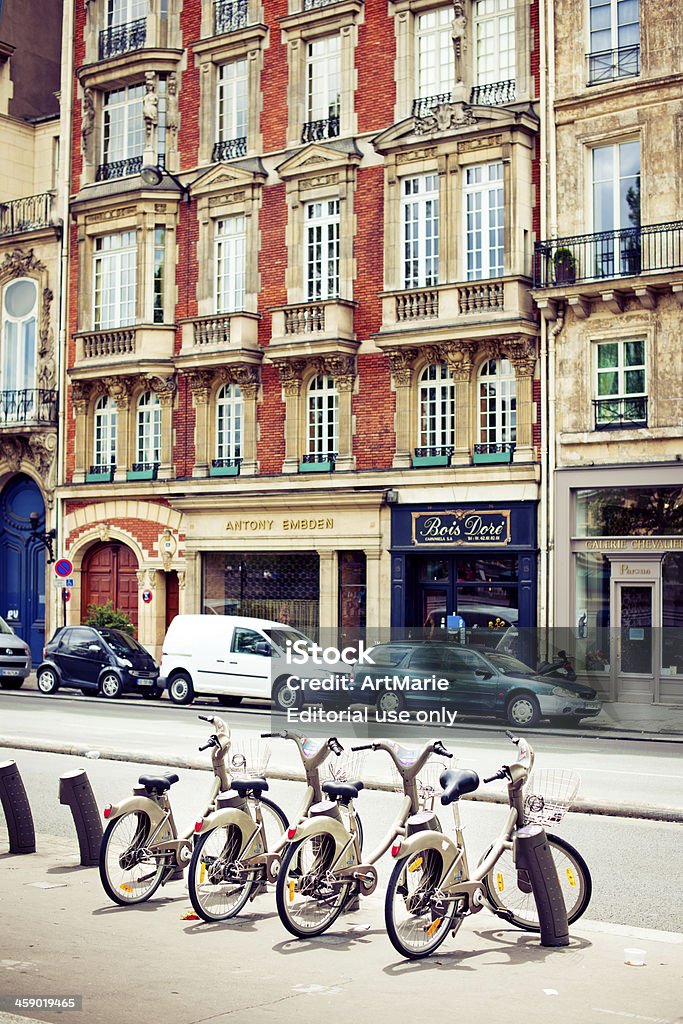 Bikes for rent in Paris "Paris, France - July 7, 2012: Automatic rent-a-bike station on a street of Paris with the classical well known Parisian architecture in the background" Architecture Stock Photo