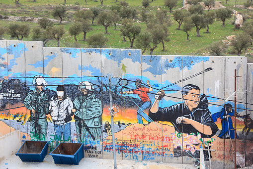 Bethlehem, West Bank (Palestine) - February 14, 2013: Grafitti on Israeli West Bank barrier. It is passes through the north side of Bethlehem. The photo was taken by Palestinian side. The Israeli West Bank barrier is a separation barrier under construction by the State of Israel along and within the West Bank. Upon completion, the barriers total length will be approximately 700 kilometers.