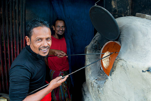 mann nimmt nang aus dem ofen, khulna, bangladesch - benglalese stock-fotos und bilder