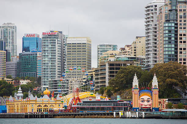 Luna Park and North Sydney "Sydney, NSW, Australia - December 11, 2012: Opened in 1935, Sydneyaas Luna Park amusement area is now overshadowed by the high rise office and apartment buildings of North Sydney" sharp corporation stock pictures, royalty-free photos & images