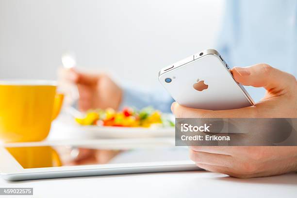 Businessman Using Iphone And Ipad Stock Photo - Download Image Now - Adult, Analyzing, Apple Computers