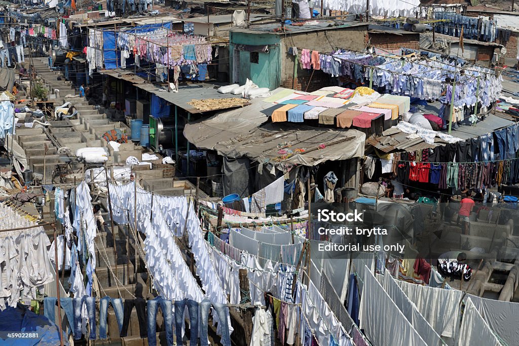 Dhobi ghats in Mumbai Mumbai,India - January 23, 2013: Open - air laundry in the center of Mumbai. Laundrymen ( dhobis ) collect the dirty clothes and linen, wash it, and return it  ironed at the owners.The municipality of Mumbai gives out over 800 washing pens  (each fitted with a beating stone) on rent individually to the dhobis at Mahalaxmi Dhobi Ghat. Located near the Mahalaxmi railway station. Adult Stock Photo