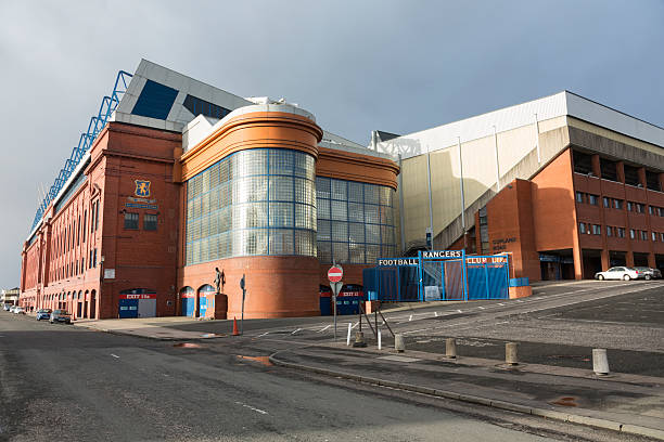 Ibrox Stadium, Glasgow "Glasgow, UK - January 30, 2013: The Bill Struth Main Stand and Copland Road Stand at Ibrox Stadium, Glasgow, the home ground of Rangers Football Club. The main stand was built in 1928 with an impressive red brick facade. Pedestrians are passing in front of the main stand along Copland Road." ibrox stock pictures, royalty-free photos & images