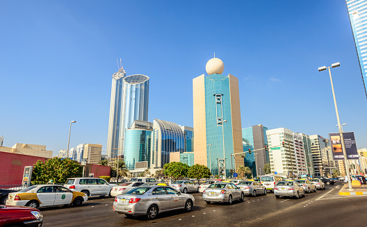 Abu Dhabi, United Arab Emirates - November 12, 2012: View on the busy Zayed the 1st Street in downtown Abu Dhabi with the landmarks Etisalat Head Office building and the newly constructed Central Market Towers on the left. 