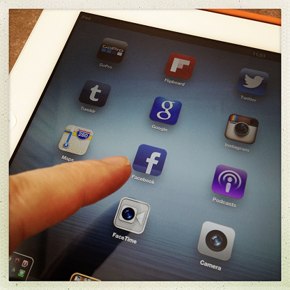  İstanbul,Turkey - February 05, 2013: Touching the Facebook icon on iPad screen.Social Media Applications on Ipad.