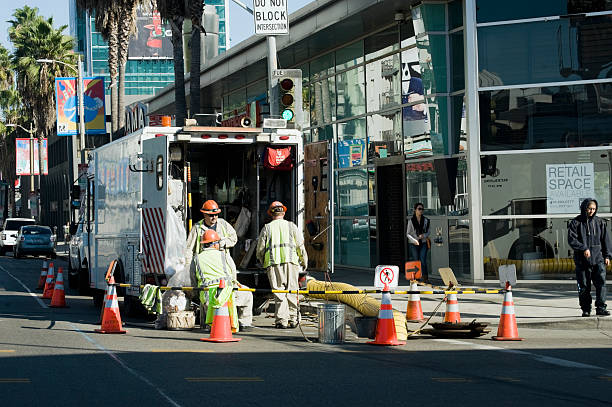 calle de trabajo - manhole construction safety mid adult men fotografías e imágenes de stock