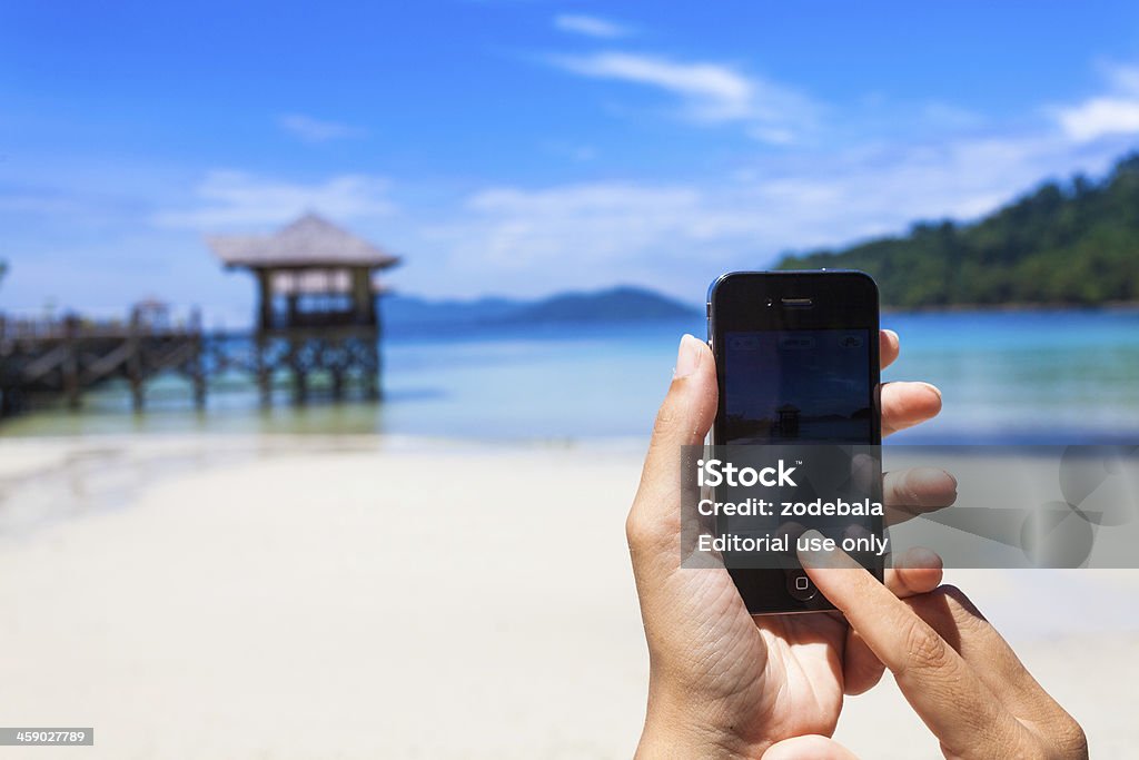 Tomar fotos en una isla Tropical con Smartphone (Iphone) - Foto de stock de Actividades recreativas libre de derechos