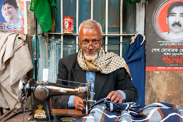 bengalische mann hinter der nähmaschine blick in die kamera - benglalese stock-fotos und bilder