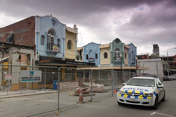Christchurch Red Zone "Christchurch, New Zealand - March 4, 2013: A police car drives past damaged buildings on New Regent St near Cathedral Square. Parts of the Christchurch CBD have been fenced off and declared a red zone as the city rebuilds and recovers from the devastating February 2011 Christchurch earthquake." christchurch earthquake stock pictures, royalty-free photos & images
