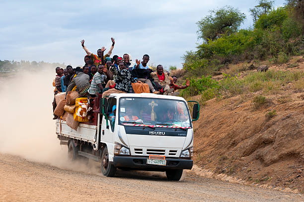 Konso, Ethiopia - August 9, 2010: An Isuzu truck filled with people, cargo, and several chickens travels down a dirt road near Konso, Ethiopia. Isuzu trucks are a common mode of public transportation in southern Ethiopia.