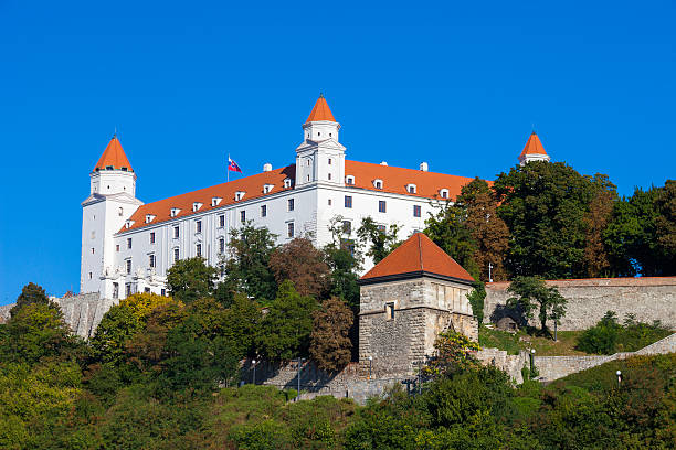 Bratislava castle "Bratislava, Slovakia - September 13, 2011: View of Bratislava castle which occupies a prominent location in the city overlooking the Danube river. On close inspection, people can be seen on the edge of a wall looking out and enjoying the view." bratislava castle bratislava castle fort stock pictures, royalty-free photos & images