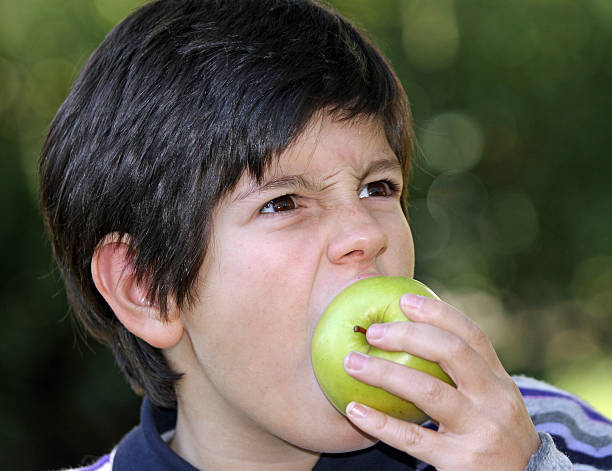 istock hungry child bite with voracity a ripe apple 459033389