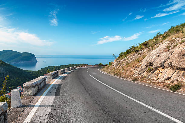 istock Turning mountain highway with blue sky and sea 459035733
