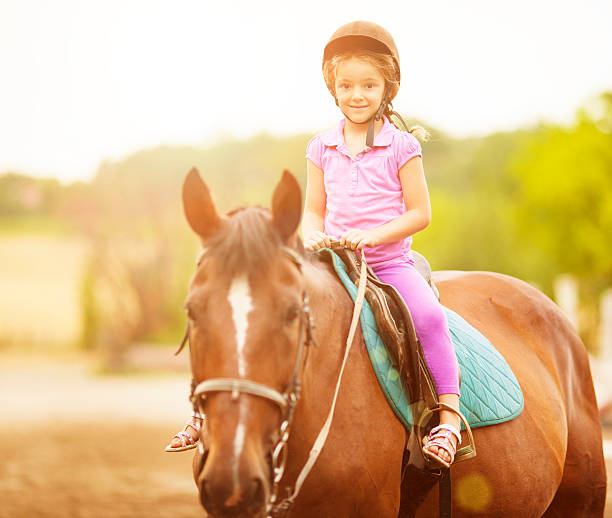 istock Child Riding Horse Outdoors. 459037157