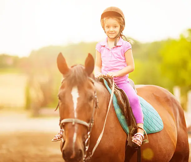 Photo of Child Riding Horse Outdoors.
