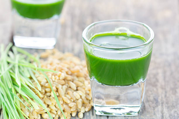istock Wheat grass juice on wood background 459037373