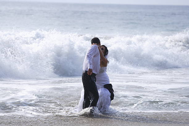 istock Bride and groom kissing at the beach 459038117