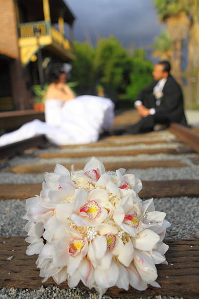 Bride and groom sitting on railroad