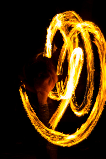 Twirling fire stick in fire show