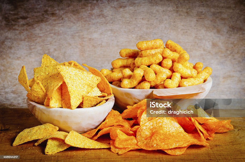 Chips, nachos and curls Chips, nachos and curls snacks on a wooden background Throwing Stock Photo