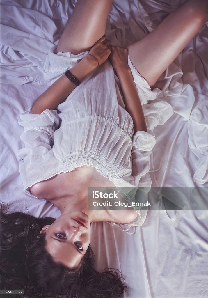 Hermosa mujer joven en vestido blanco en la cama - Foto de stock de Accesibilidad libre de derechos