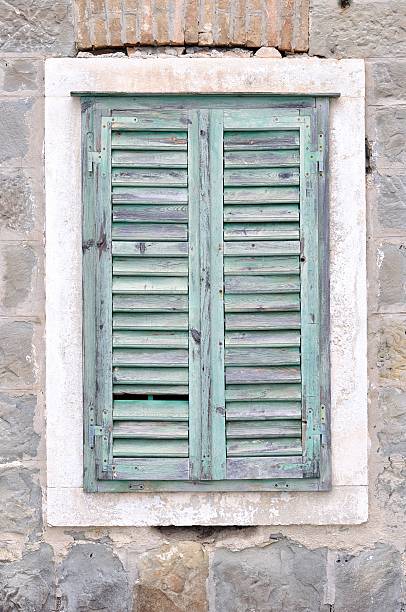 istock Old window with blue closed shutters on a house 459044779