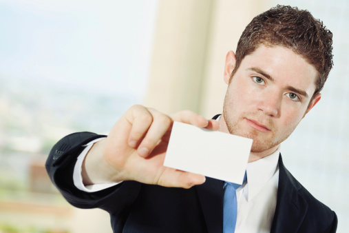 Stock image of caucasian businessman showing business card