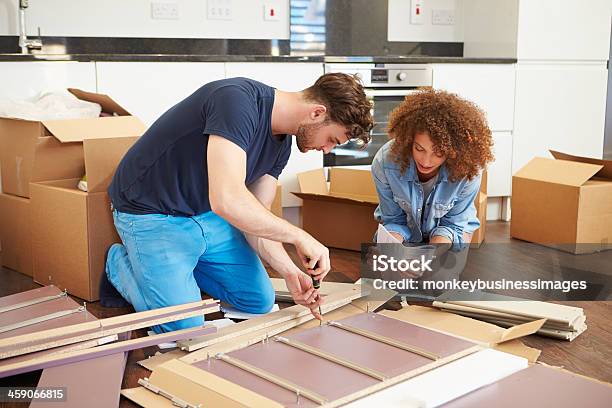 Couple Putting Together Self Assembly Furniture In New Home Stock Photo - Download Image Now