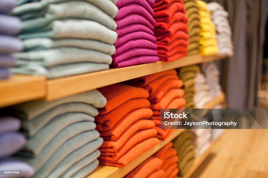 Colorful display of sweaters on shelf in store Different color of Sweaters for sale Clothing Stock Photo