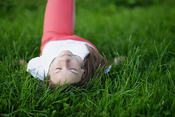 istock young attractive girl lying on the grass 459084049