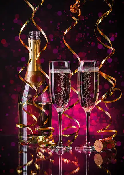 Two champagner glasses on glass table with bokeh background