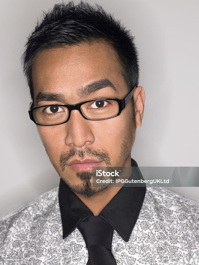 Closeup Portrait Of Man Wearing Glasses Closeup portrait of a man wearing glasses against gray background Filipino Ethnicity Stock Photo
