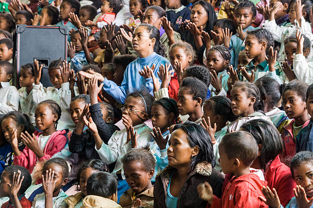 Father Pedro Opeka Antananarivo, Madagascar - October 7, 2007: People prying during a mass of Father Pedro Opeka in the church of the village of Akamasoa, Antananarivo, Madagascar.  praying child christianity family stock pictures, royalty-free photos & images