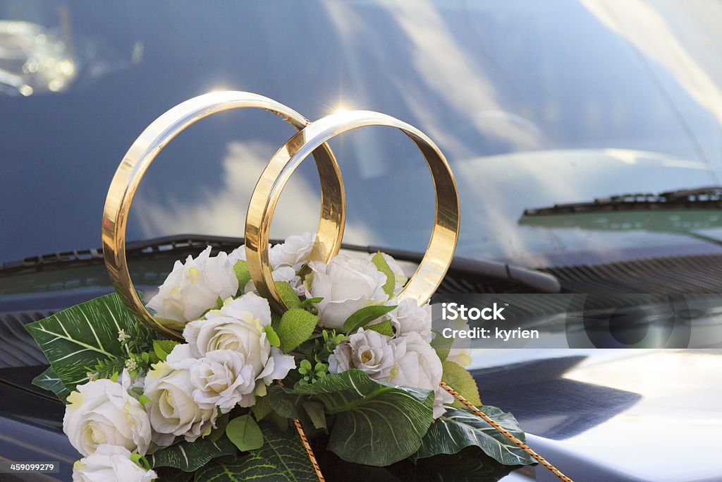 Spray, flower arrangement for a wedding on car A flower arrangement with big golden rings for a wedding on a black car Arrangement Stock Photo