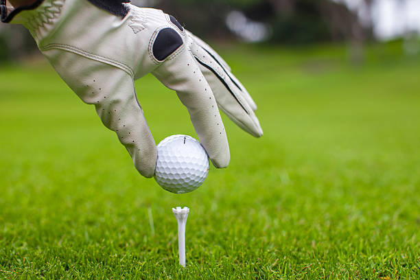 istock Man's Hand hold golf ball with tee on course 459118483