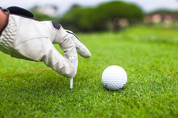 istock Hand placing golf-ball on tee over beautiful golf course 459120897