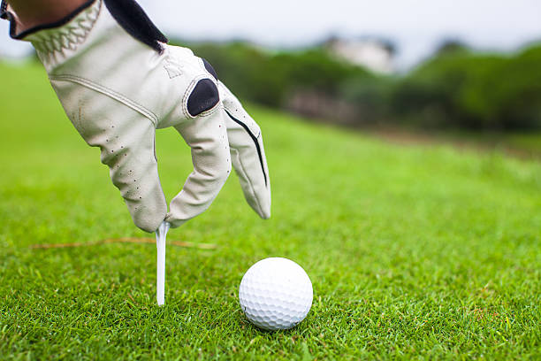 istock Hand placing golf-ball on tee over beautiful golf course 459120913