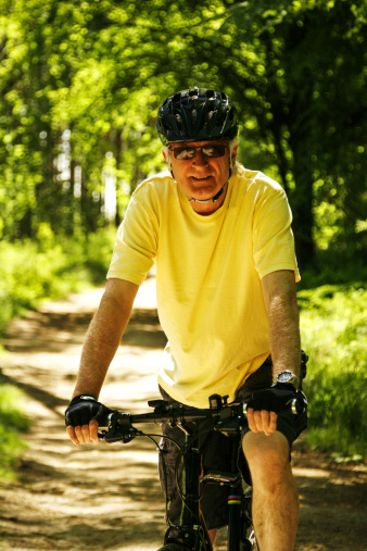 Man cycling on forest path.