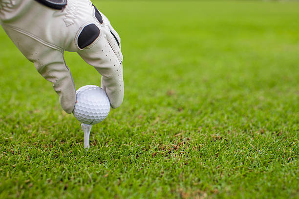 istock Hand placing golf-ball on tee over beautiful golf course 459148545