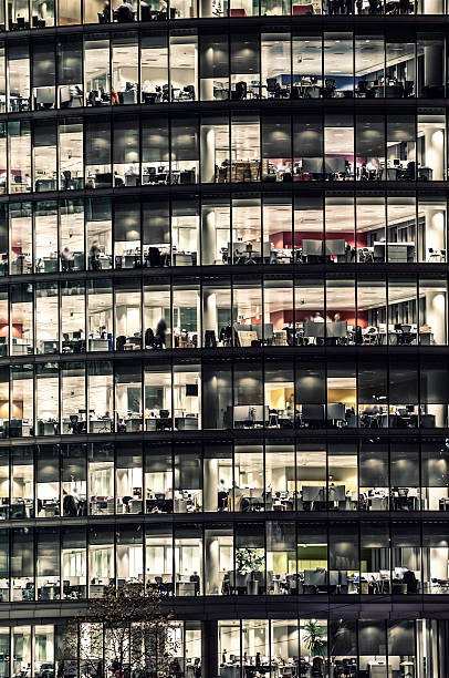 istock Office building at night with people working - II 459151517