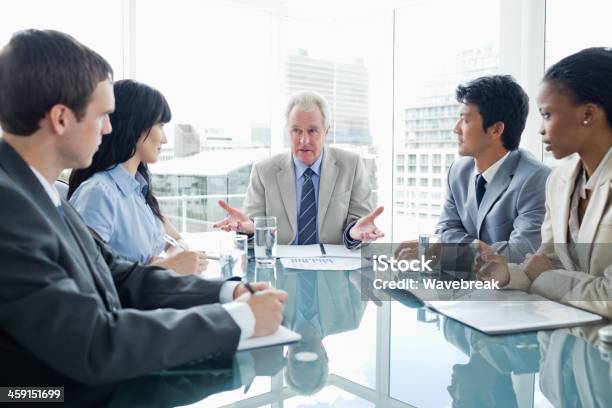 Mature Businessman Talking Seriously To His Employees Stock Photo - Download Image Now