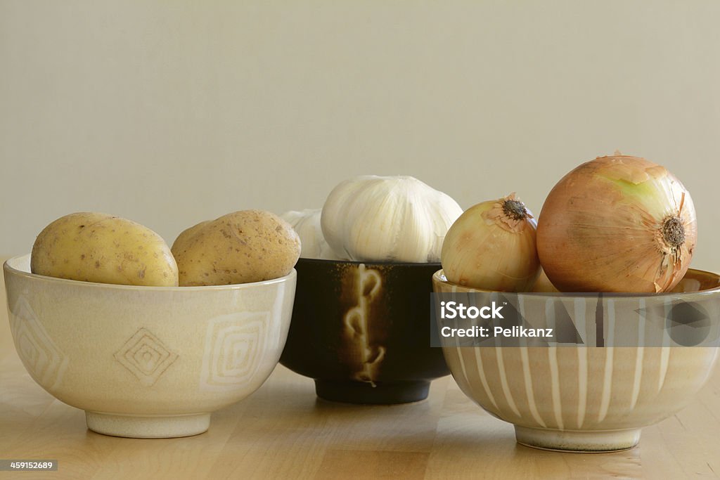 Des pommes de terre, oignons et l'ail dans des bols - Photo de Agriculture libre de droits
