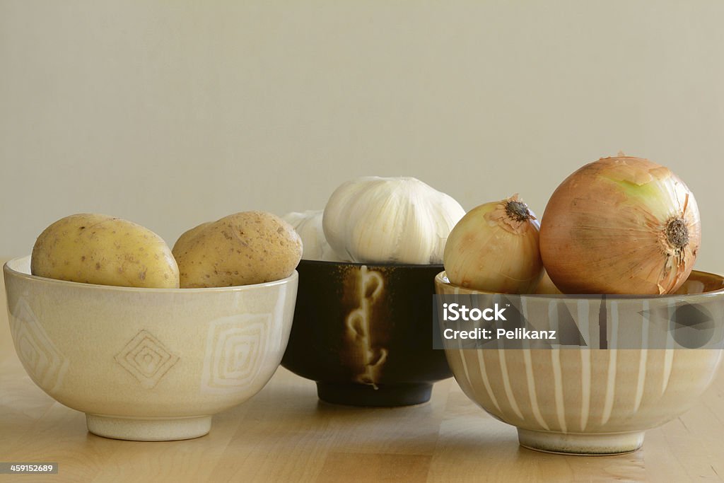 Batatas frescas, alho e cebola em tigelas - Foto de stock de Agricultura royalty-free