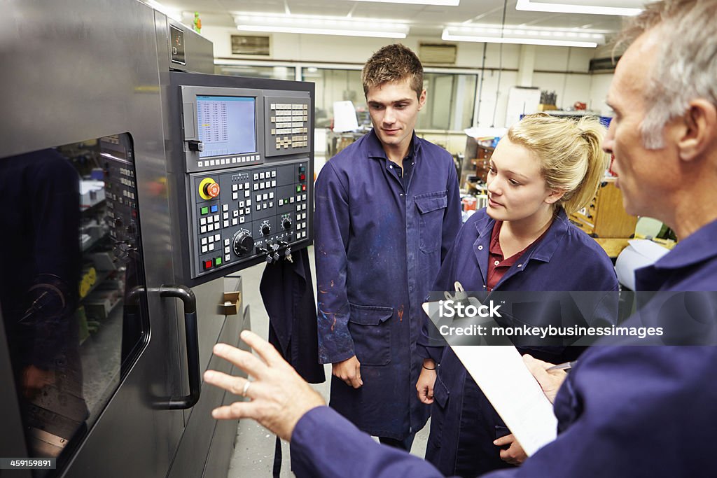 Ingénieur étudiants apprendre à utiliser informatisé Machine-outil - Photo de Machinerie libre de droits