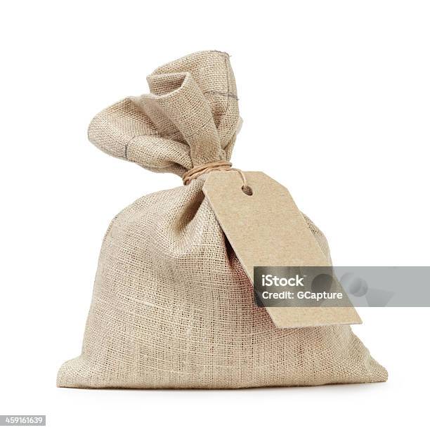 A Tied Up Sack Type Of Bag With A White Paper Tag Stock Photo - Download Image Now - Sack, Coin, Canvas Fabric